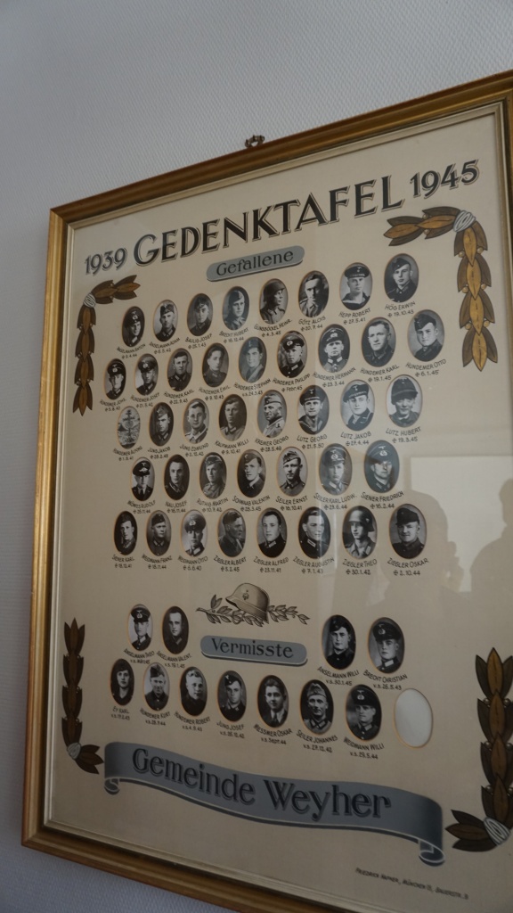  1, 2차 대전 때 목숨을 잃거나 행방불명된 마을 사람들의 사진이 의회 사무실 벽에 걸려있다.